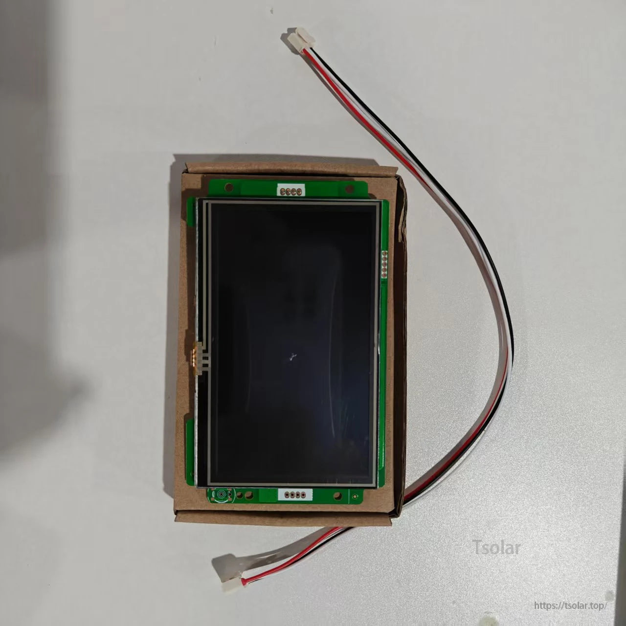 LCD display module for BMS, front view on cardboard tray with two wire leads