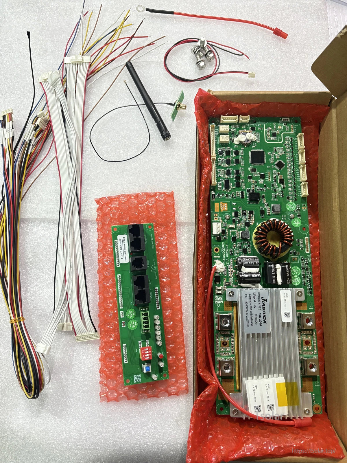 JBD Smart BMS kit contents laid out: main BMS board, interface board, and wiring harness leads